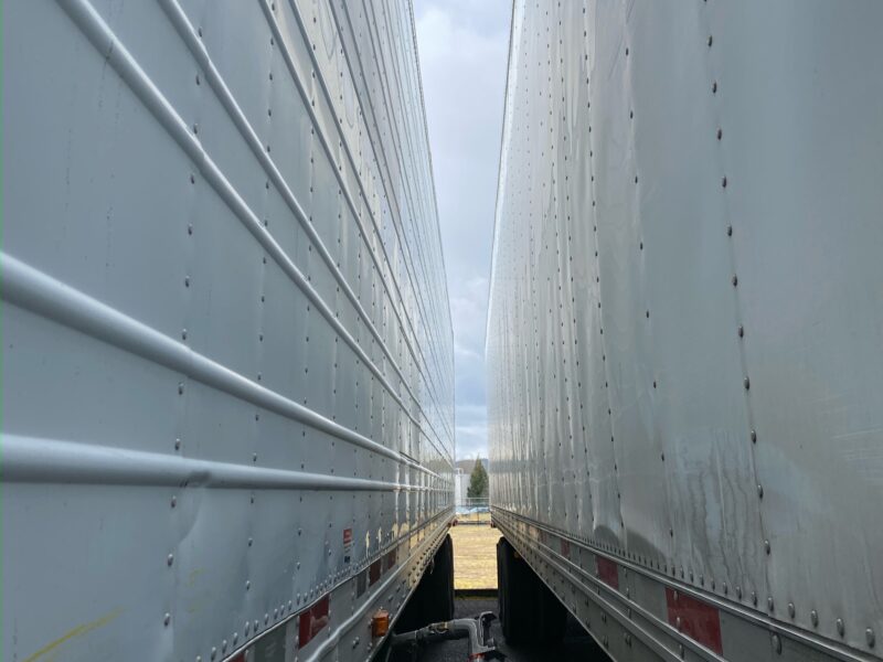 Mobile fueling hose delivering diesel between two parked trailers