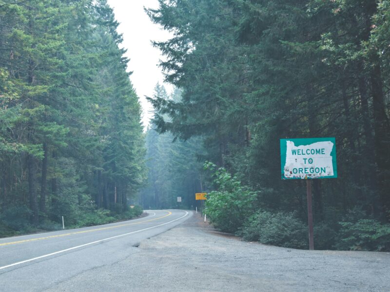 Welcome to Oregon road sign on a forested highway