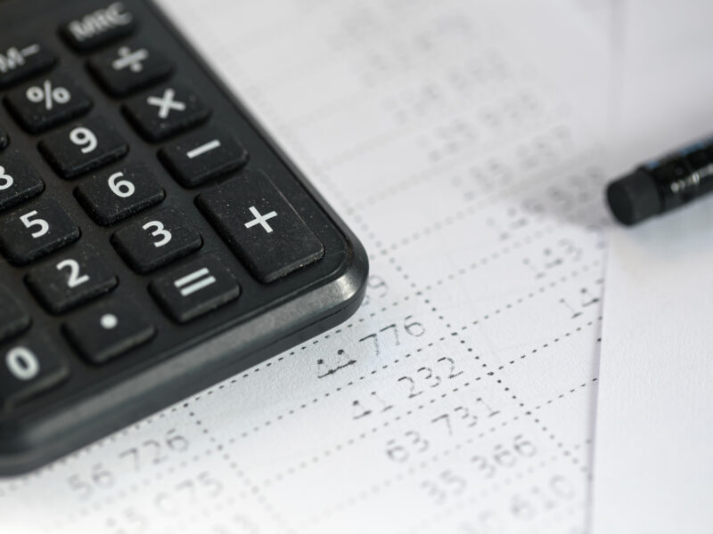 Close-up of calculator and printed fuel cost audit spreadsheet