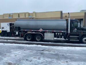 Star Oilco fuel tanker truck delivering diesel to refrigeration unit during icy winter conditions