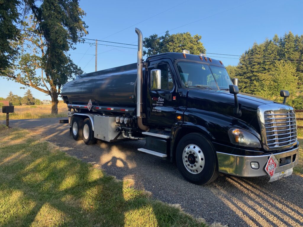 Star Oilco black fuel truck parked on rural road with trees in background