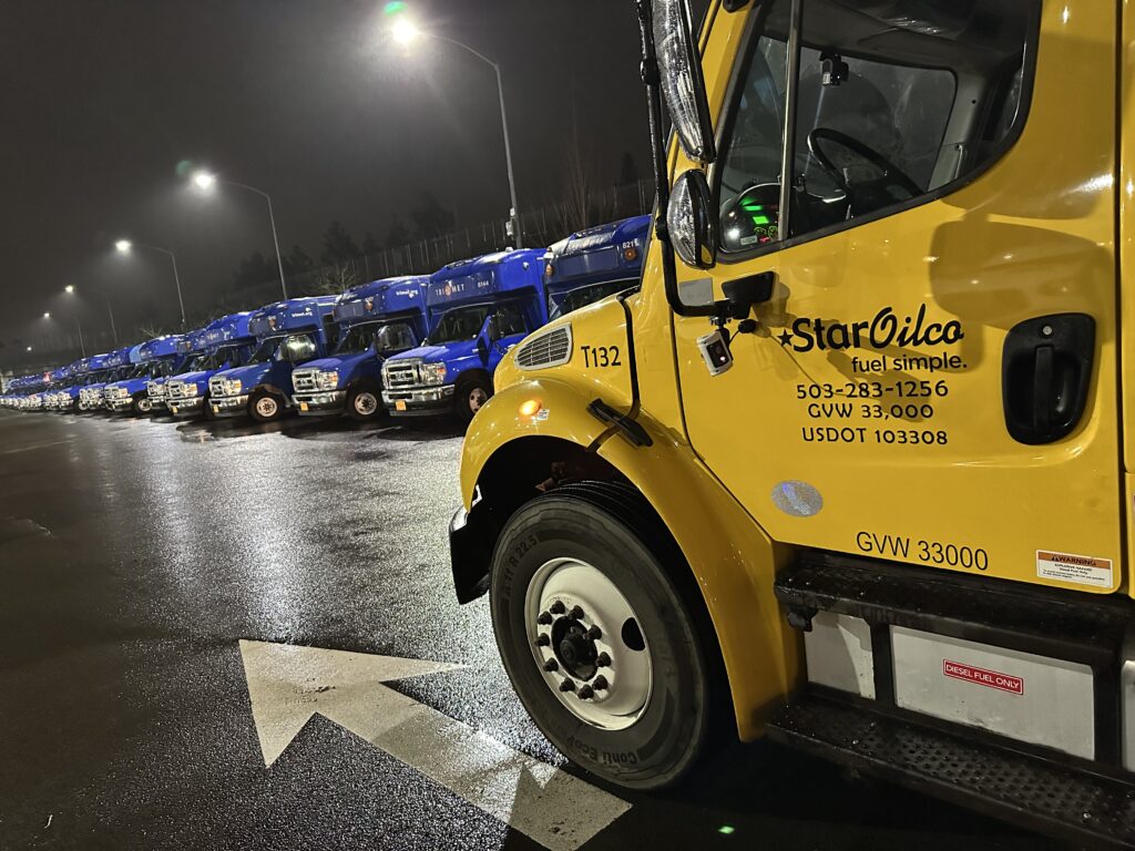 Star Oilco yellow fuel truck providing on-site fleet fueling service at a commercial truck lot at night
