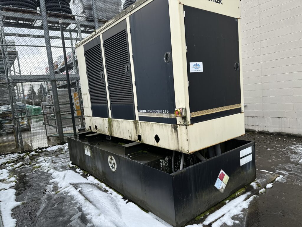 Large Kohler diesel generator in an industrial yard with snow on the ground