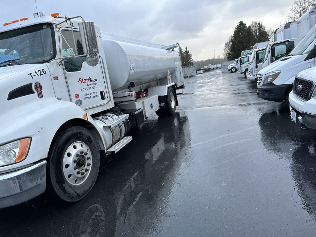 Star Oilco white fuel delivery truck parked in a lot under wet pavement